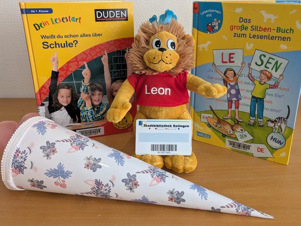 Zwei Bücher, eine Schultüte und ein Plüschlöwe mit Leseausweis der Stadtbücherei