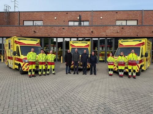 Personengruppen stehen vor drei Rettungswagen