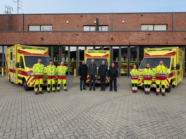 Personengruppen stehen vor drei Rettungswagen
