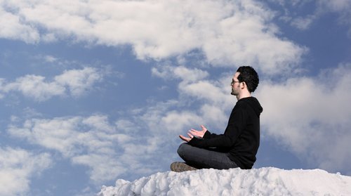 Mann sitzt auf einer Wolke