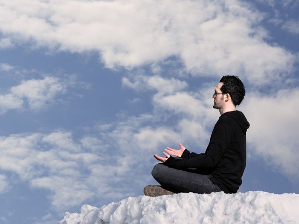 Mann sitzt auf einer Wolke