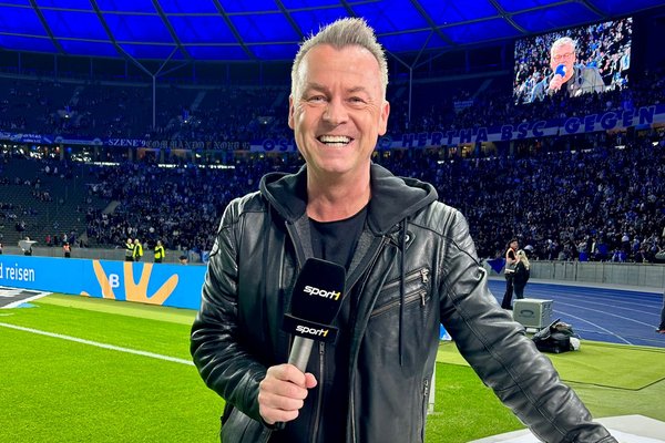 Oliver Forster mit Mikro im Stadion am Spielfeldrand