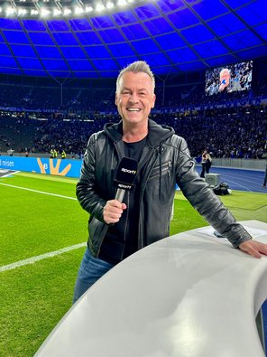 Oliver Forster mit Mikro im Stadion am Spielfeldrand