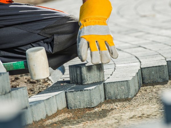 Mann bei Pflasterarbeiten 