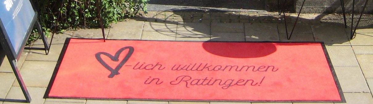 Roter Teppich mit Schriftzug "Herzlich willkommen in Ratingen!"