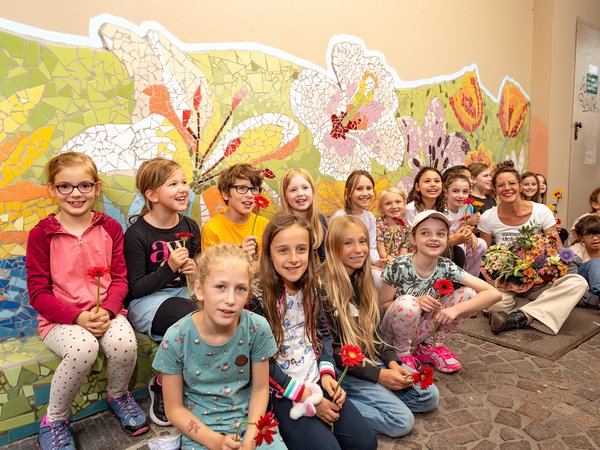 Kinder vor einer Mosaikwand