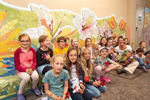 Kinder vor einer Mosaikwand