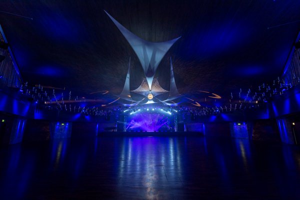 Großer Saal mit illuminiertem Vorhang und Bühnenbeleuchtung. 