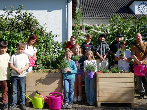 Kinder und Jugendliche mit zwei Hochbeeten