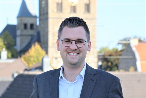 Junger Mann mit St. Peter und Paul im Hintergrund