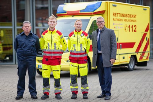 Vier Männer vor einem Rettungswagen