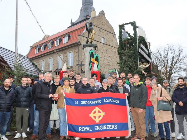 Gruppe Männer mit Fahne vor dem Weihnachtsmarkt