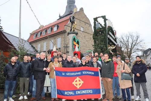 Gruppe Männer mit Fahne vor dem Weihnachtsmarkt