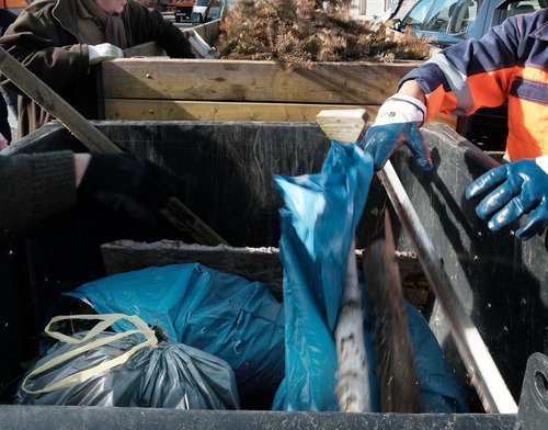 Blaue Plastiksäcke in einem Müllcontainer.