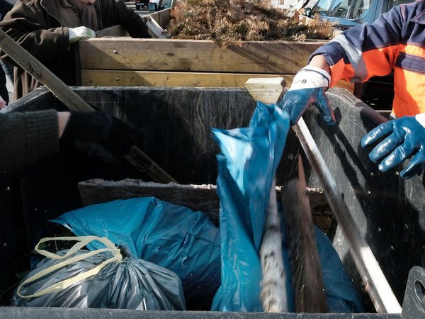 Blaue Plastiksäcke in einem Müllcontainer.