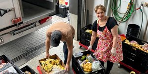 Mitarbeitende der TAFEL Ratingen räumen Kisten mit Lebensmitteln aus einem Kleintransporter