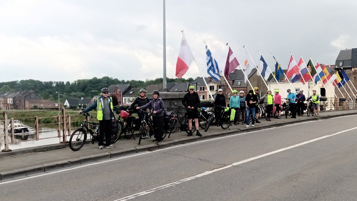 Radfahrer auf einer Brücke mit verschiedenen Länderfahnen