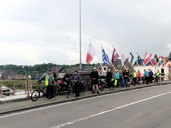 Radfahrer auf einer Brücke mit verschiedenen Länderfahnen