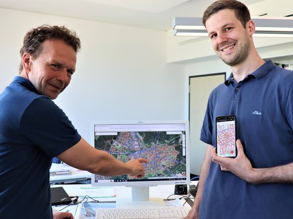 Zwei Männer mit Computer und Handy.