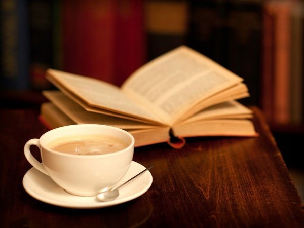 Eine Tasse Kaffee und ein Buch auf einem Tisch