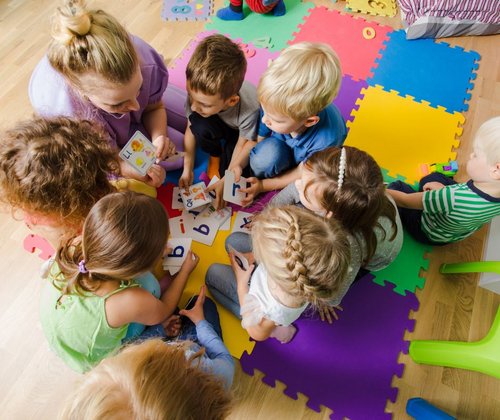 Kinder sitzen im Kreis auf dem Boden