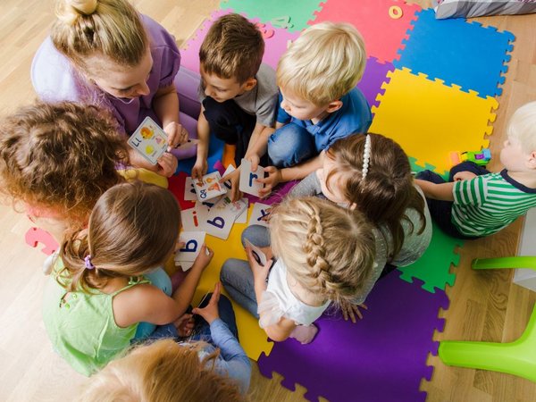Kinder sitzen im Kreis auf dem Boden