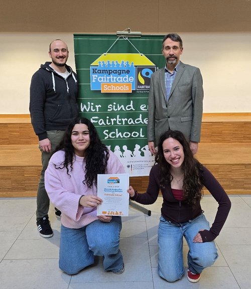 Zwei Männer und zwei Mädchen mit Urkunde