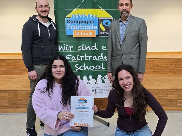 Zwei Männer und zwei Mädchen mit Urkunde