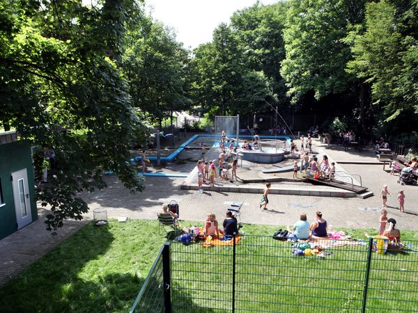 Belebter Wasserspielplatz und grüne Umgebung  