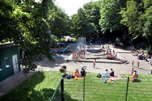 Belebter Wasserspielplatz und grüne Umgebung  