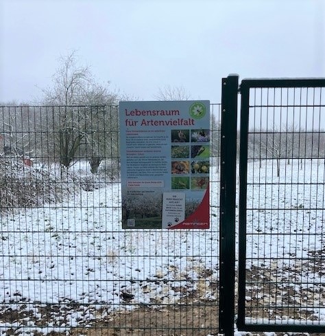 Infoschild hängt an einem Zaun